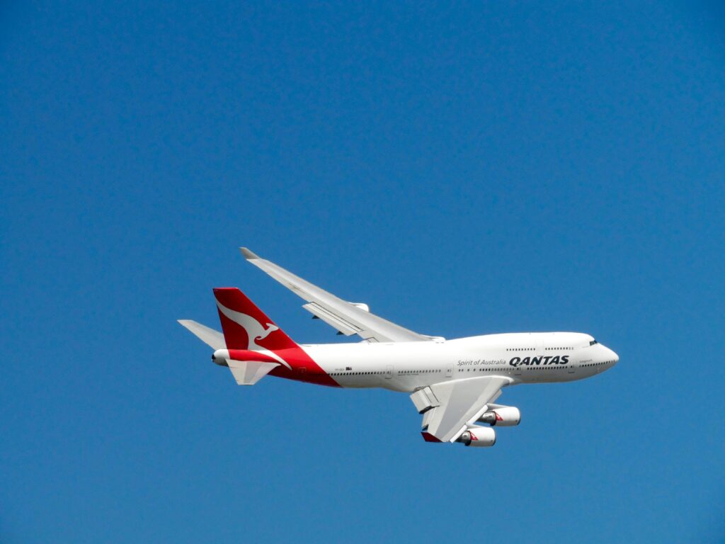 Qantas Boeing 747 captured mid-flight against a clear blue sky, symbolizing aviation and travel.