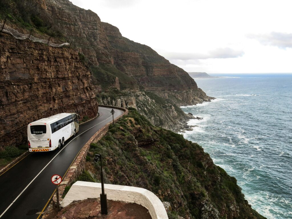 White Bus on Road Near Cliff